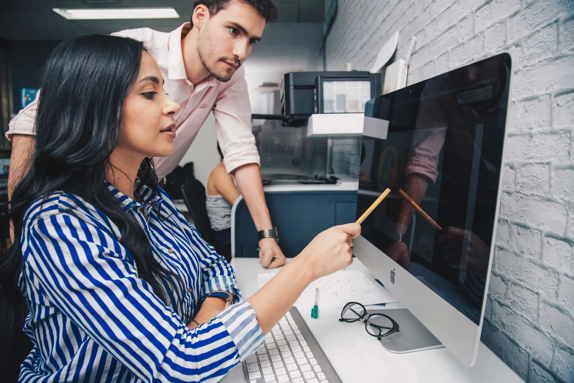 Two colleagues going over records together at a computer.